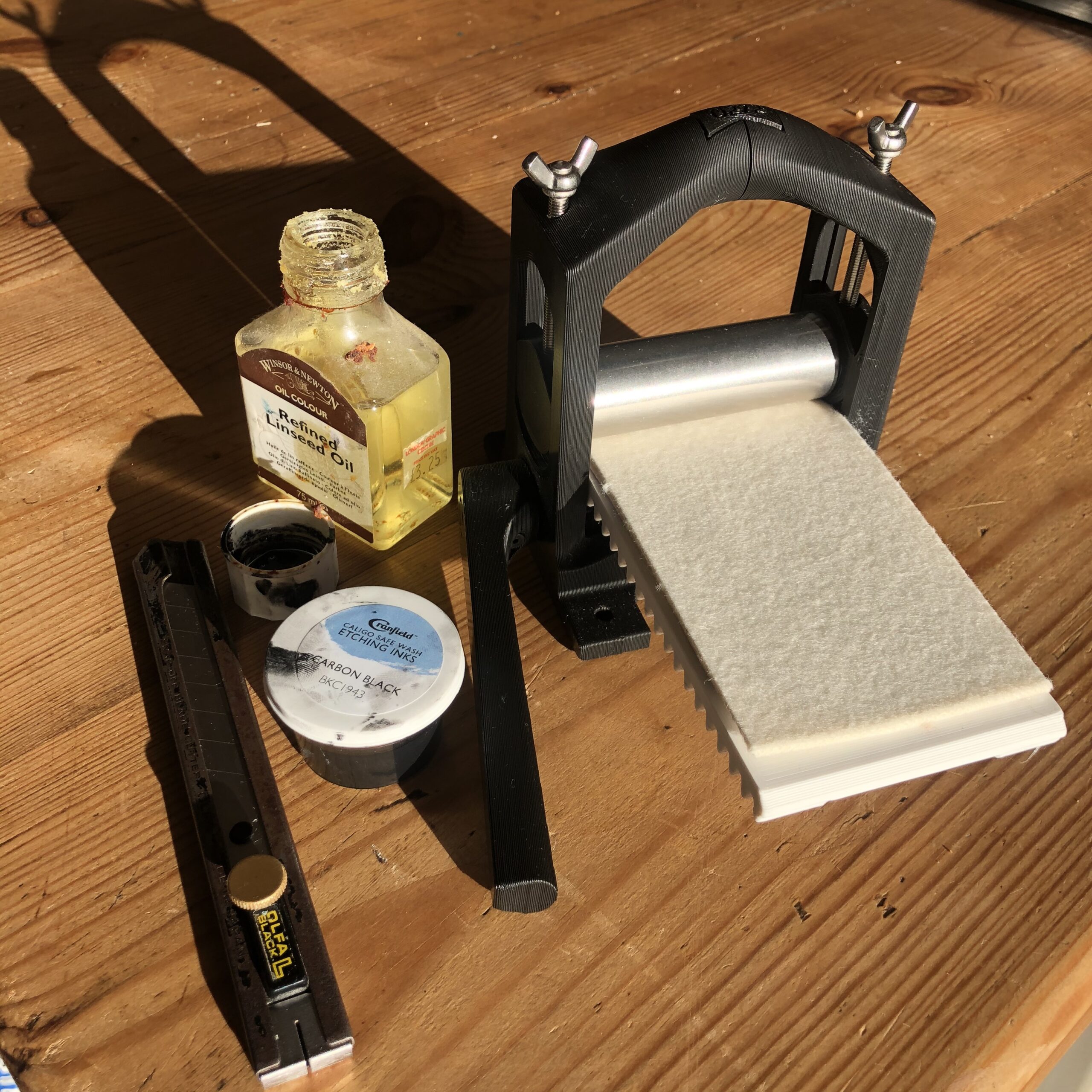 Tiny printing press with linseed oil bottle and ink